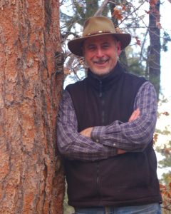 Chas Clifton standing by large tree